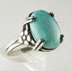 This is a sterling silver ring with a Natural American Turquoise oval stone. The gorgeous setting has flower details on either side of the turquoise. Handmade to order in size 5-11. Dimensions: stone 12x16mm Vintage Turquoise Ring With Large Stone, Vintage Turquoise Rings With Natural Stones, Vintage Turquoise Ring With Natural Stones, Vintage Turquoise Ring With Large Stone For Gift, Vintage Turquoise Cabochon Ring, Vintage Cabochon Turquoise Ring, Vintage Blue Turquoise Ring With Natural Stones, Antique Turquoise Gemstone Ring, Vintage Turquoise Ring With Oval Cabochon