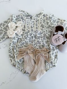 This long sleeve baby romper features a high neck and ruffled trim, perfect for keeping your little one stylish and comfortable. Made from soft cotton material, this romper also sports a beautiful floral print, adding a touch of charm and sophistication to any outfit. Spring Long Sleeve Ruffled Onesie, Cute Long Sleeve Cream Bubble Romper, Fitted Long Sleeve Onesie With Ruffles, Fitted Long-sleeved Onesie With Ruffles, Cute Long Sleeve Bubble Romper For Spring, Long Sleeve Cream Onesie For Spring, Cream Long Sleeve Bubble Romper For Summer, Cream Long Sleeve Onesie For Spring, Cute Long Sleeve Onesie With Ruffles