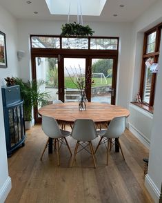 a dining room table surrounded by chairs and windows