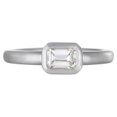 a white gold ring with an emerald cut diamond