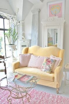 a living room filled with furniture and a pink rug on top of a carpeted floor