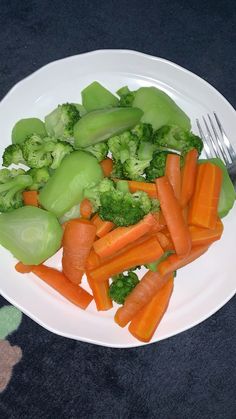 a white plate with carrots, broccoli and celery on it