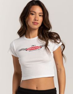 Honda Baby Tee. Graphic Screened Across Center Chest. Ribbed Crew Neckline. Short Sleeve. Shrunken Fit. 100% Cotton. Machine Wash. Imported.officially Licensed. Model Is Wearing A Size Small. Model Measurements:height: 5'6" Bust: 32"waist: 26"hips: 35" Trendy Fitted Top With Front Print, Y2k Cotton Tops With Front Print, Fitted White Tops For Streetwear, White Fitted Top For Streetwear, Sporty White Tops With Front Print, Fitted Tops With Front Print For Spring, Fitted Spring Tops With Front Print, Sporty White Top With Front Print, White Sporty Top With Front Print