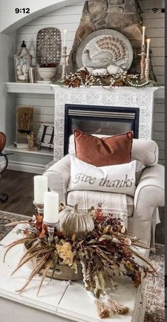 a living room filled with furniture and a fire place covered in fall decorations on top of a white coffee table