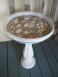 there is a glass table with shells on it