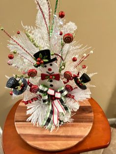 a snowman is sitting on top of a table with candy canes and decorations