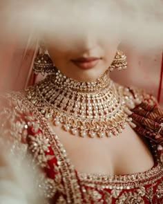 a woman in a red and gold bridal outfit