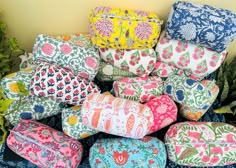 a pile of colorfully patterned bags sitting on top of a table