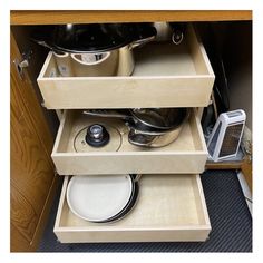 an open drawer with pots and pans in it