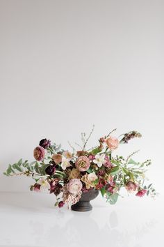 a vase filled with lots of flowers on top of a table