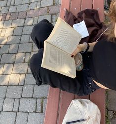 a person sitting on a bench reading a book