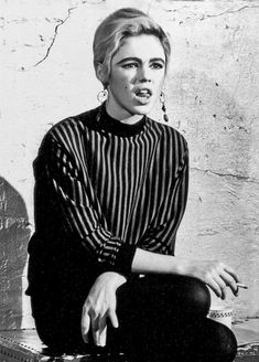 a black and white photo of a woman sitting on top of a suitcase with her mouth open