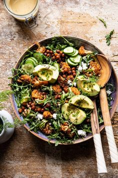 a salad with avocado, chickpeas and other ingredients in a bowl