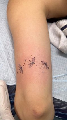 a woman's leg with three dragonflies on it