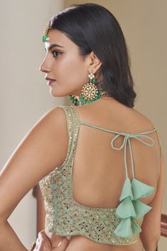 This 3-piece set features a green Titan Silk lehenga choli with 10 meters of flair and a Butterfly Net dupatta. It is standard cancan and canvas attached. The entire set is detailed with dori, mirror, zari and sequins embroidery. The blouse is sleeveless, round necked with back dori and tassels, and measures 0.8 meter. The lehenga is floor-length and flared. Dry-cleaning is recommended for this set. Customizations are available upon checkout; simply add your measurements in the “Order Notes” box Blouse With Dori Design, Dori For Lehenga, Back Dori Designs, Dories For Blouse, Blouse Dori Designs, Dori Blouse Designs, Dori Designs, Dori Blouse, Choli Blouse Design