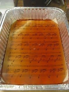 an aluminum pan filled with orange liquid and music notes