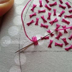 a close up of a piece of cloth with pink thread on it