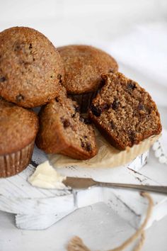 some muffins sitting on top of a white plate next to a knife and fork