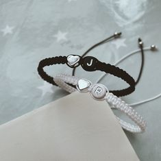 Personalised Matching Couples bracelet set is a cute gift for your girlfriend boyfriend celebrating your anniversary or your partners birthday. 𝔸𝕓𝕠𝕦𝕥 𝕥𝕙𝕖 𝕓𝕣𝕒𝕔𝕖𝕝𝕖𝕥 - 2mm black and white knotting cord - 5mm round letter bead with silver letter -silver plated heart charm long lastig  - adjustable knot(see picture) ℍ𝕠𝕨 𝕀 𝕠𝕣𝕕𝕖𝕣? - select Options: Set of 2(to receive 2 bracelets) - personalization box Example: black bracelet letter A(black and silver) + heart charm White bracel Black Braided Bracelets For Valentine's Day Gift, Black Braided Bracelet For Valentine's Day Gift, Casual Black Friendship Bracelets For Valentine's Day, Handmade Black Braided Bracelets For Valentine's Day, Handmade Black Braided Bracelet For Valentine's Day, Personalized Black Friendship Bracelets For Birthday, Personalized Adjustable Black Friendship Bracelets, Personalized Black Friendship Bracelet For Birthday, Adjustable Black Friendship Bracelets As Personalized Gift