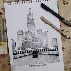 a drawing of a clock tower on top of a building next to markers and pens