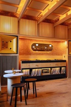 an empty room with tables, stools and records on the shelves in front of it