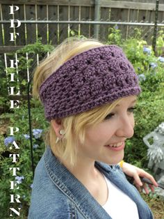 a woman wearing a crocheted headband in front of a fence and flowers