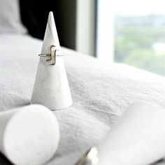 a small white cone sitting on top of a bed