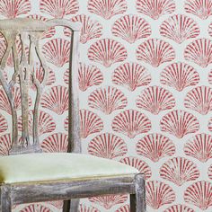 a chair sitting in front of a wall with red shells on it