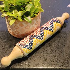 a wooden rolling pin next to a potted plant