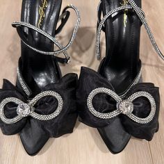 Black Satin Bow Heels. Crystal Straps Wrap Around The Ankle Twice. Size 7.5. New In Box. Never Worn. Glamorous Black Heels With Bow, Black Synthetic Heels For Events, Black Heels With 4-inch Heel For Dinner, Black Heels With Bow For Night Out, Black Heels With 4-inch Heel For Events, Black Glamorous Heels For Events, Glamorous Black Heels For Events, Black Heels With Wrapped Heel For Dinner, Black High Heel Heels For Events