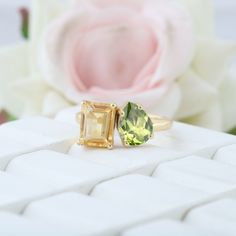 two yellow and green rings sitting on top of a white surface next to a flower