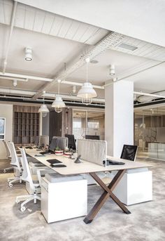 an office space with desks, computers and chairs in the middle of the room