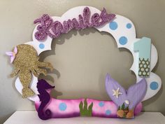 a pink and purple mermaid themed frame with glitter name on it