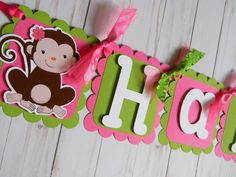 a pink and green banner that says happy with a monkey on the letter'h '