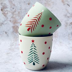 two cups with christmas trees painted on them