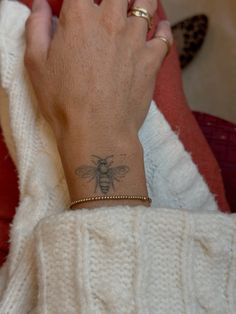 a woman with a bee tattoo on her wrist