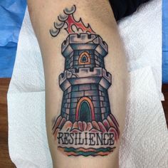 a man with a tattoo on his leg that says resilige in front of a castle