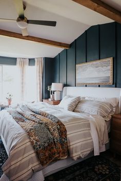 a bedroom with blue walls and white bedding