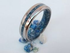 two rings with blue and white stones on the inside, one ring is made out of silver