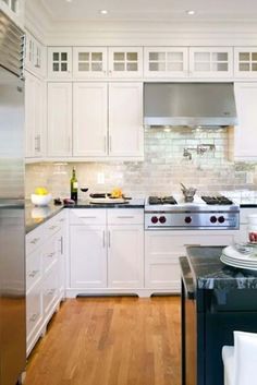 a kitchen with white cabinets and stainless steel appliances