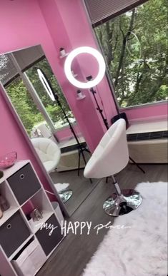 a pink room with a mirror, chair and shelves in front of the window that says happy