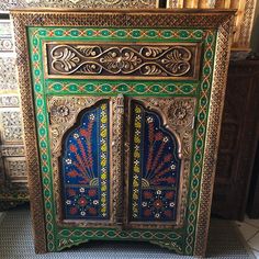 an ornately decorated cabinet in the middle of a room