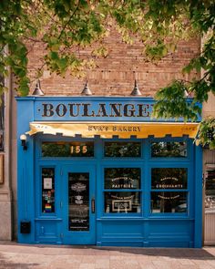 the entrance to boulange is blue and has yellow awnings on it