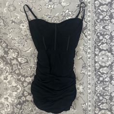 a black dress laying on top of a carpet