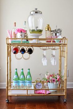 a gold bar cart filled with bottles and glasses