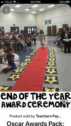 the end of the year award ceremony is being held in an auditorium with children sitting on chairs