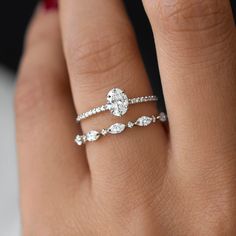 a woman's hand with two wedding rings on it