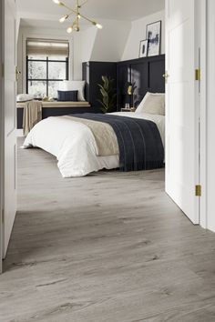 a bedroom with white walls and wood floors