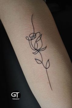 a small rose tattoo on the arm