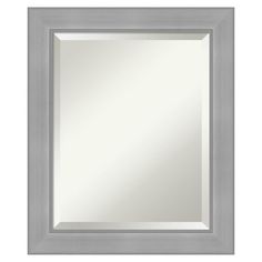 a silver framed mirror on a white wall with a gray border around the edges and bottom edge